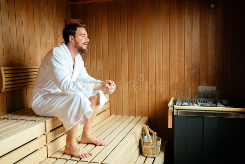 Knappe man ontspant in de sauna stock foto's