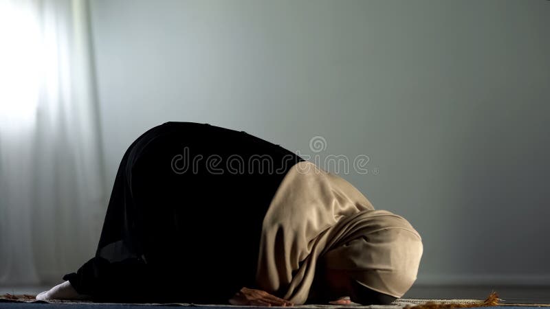 Kneeling arab woman prostrating on islamic praying rug, religious worship, faith, stock photo. Kneeling arab woman prostrating on islamic praying rug, religious worship, faith, stock photo