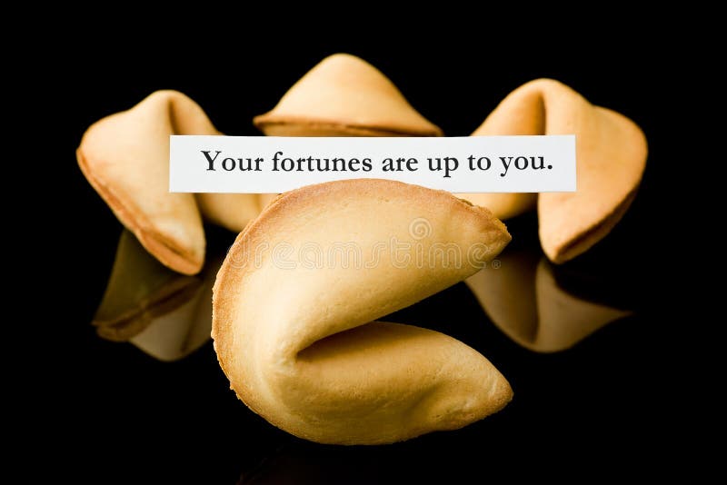 A fortune cookie with a message on a black background. A fortune cookie with a message on a black background