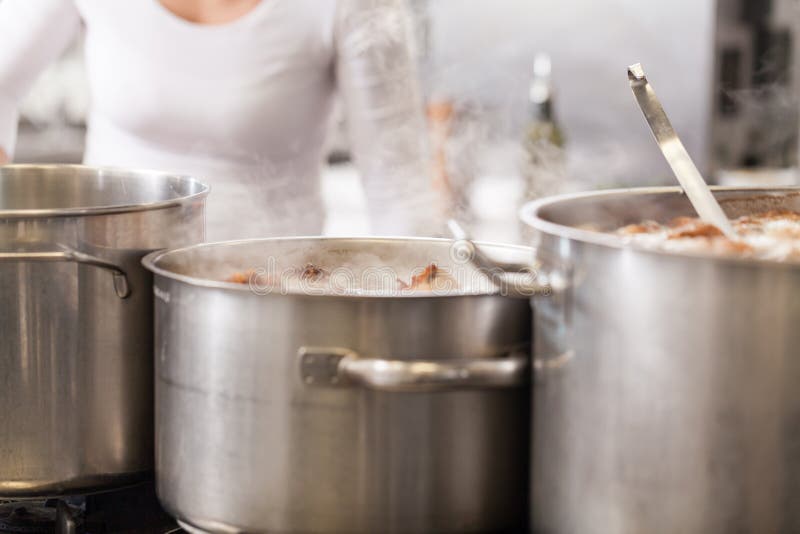 Het koken in een commerciële keuken royalty-vrije stock afbeeldingen Het koken in een commerciële keuken royalty-vrije stock afbeeldingen