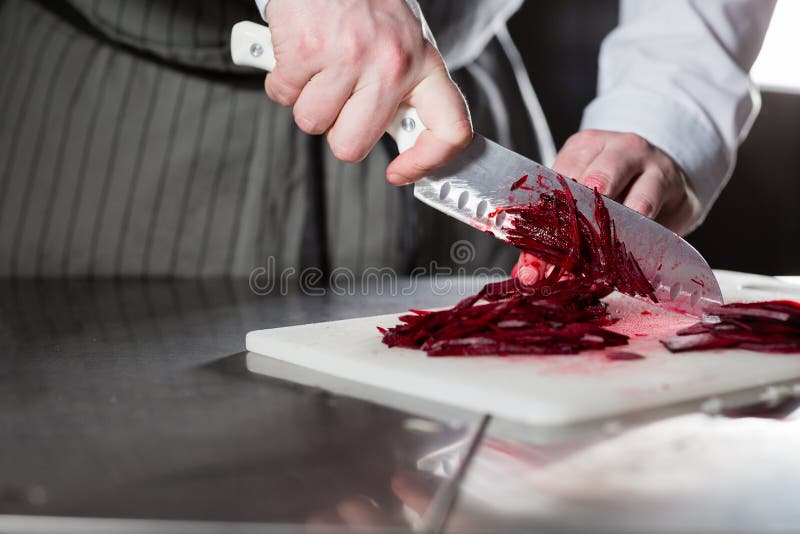 Het koken in een restaurantkeuken Close-up van hand met mes die verse groente snijden Jonge chef-kok scherpe biet op een wit royalty-vrije stock foto's Het koken in een restaurantkeuken Close-up van hand met mes die verse groente snijden Jonge chef-kok scherpe biet op een wit royalty-vrije stock foto's