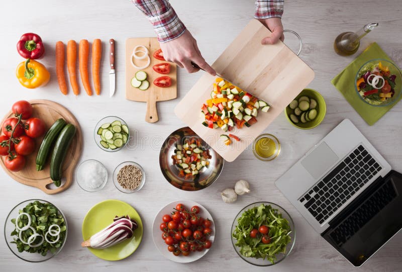 Het koken thuis met online recepten royalty-vrije stock foto Het koken thuis met online recepten royalty-vrije stock foto
