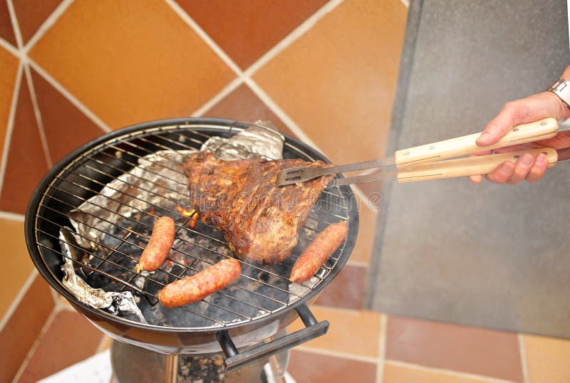 Het koken van een barbecue voor vrienden stock fotografie Het koken van een barbecue voor vrienden stock fotografie