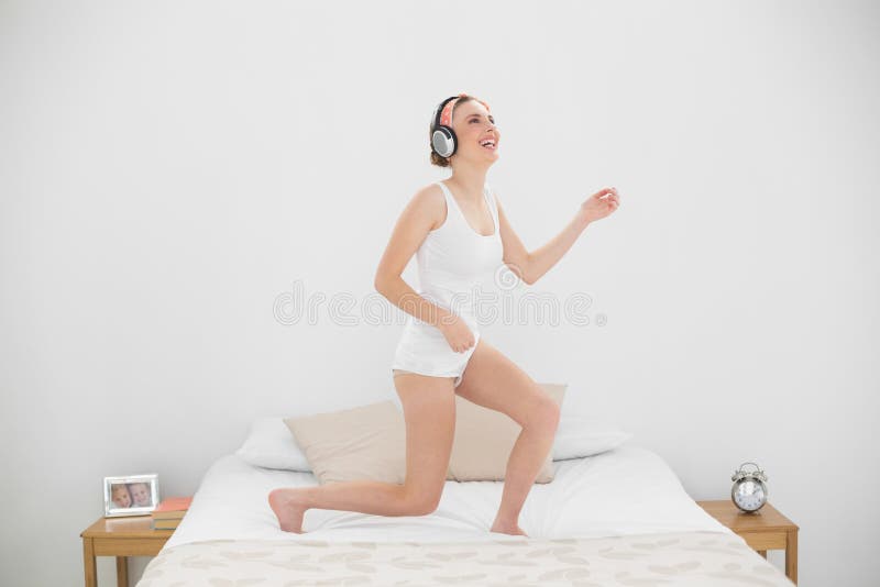 Het lachen vrouw het spelen luchtgitaar terwijl het luisteren aan muziek royalty-vrije stock afbeeldingen Het lachen vrouw het spelen luchtgitaar terwijl het luisteren aan muziek royalty-vrije stock afbeeldingen