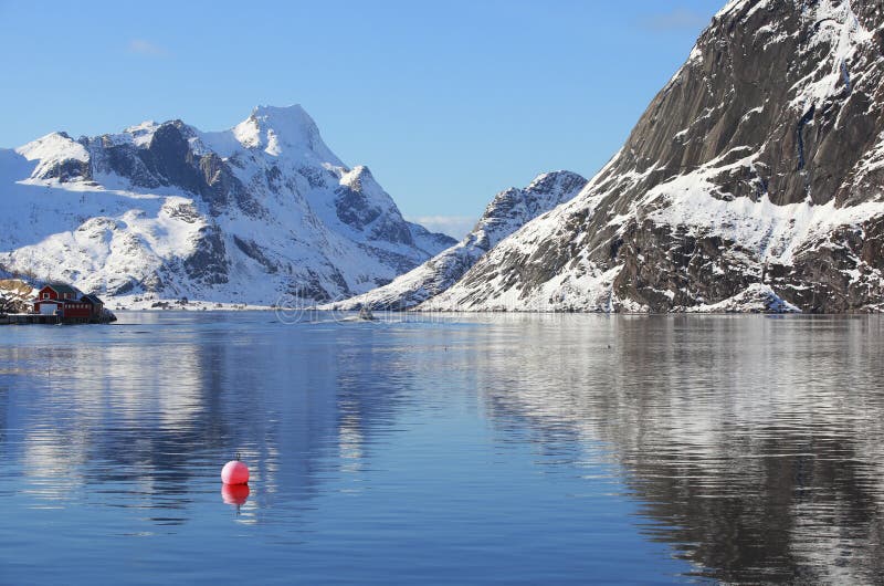 Het landschap van de landschapswinter met rode boei in het visserijdorp van Reine, Lofoten, Noorwegen, boven de noordpoolcirkel stock foto Het landschap van de landschapswinter met rode boei in het visserijdorp van Reine, Lofoten, Noorwegen, boven de noordpoolcirkel stock foto