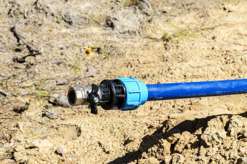 Het leggen en verbinding van een waterslang voor een priv? huis het concept het leggen van en het aansluiten van de waterpijp, sl royalty-vrije stock foto Het leggen en verbinding van een waterslang voor een priv? huis het concept het leggen van en het aansluiten van de waterpijp, sl royalty-vrije stock foto