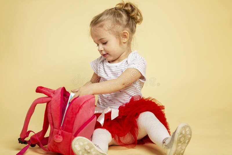 Het leuke meisje met een roze rugzak zit royalty-vrije stock afbeelding Het leuke meisje met een roze rugzak zit royalty-vrije stock afbeelding