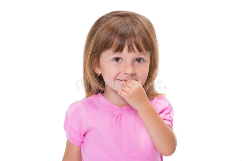 Het leuke meisje 3 éénjarigen in roze t-shirt houdt vingers in mond of bijt spijkers die op witte achtergrond worden geïsoleerd S stock afbeelding Het leuke meisje 3 éénjarigen in roze t-shirt houdt vingers in mond of bijt spijkers die op witte achtergrond worden geïsoleerd S stock afbeelding