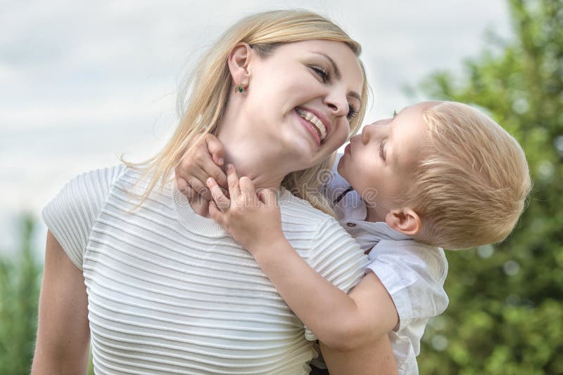 Het levensogenblik van gelukkige familie! Weinig jongen omhelst teder zijn moeder stock foto's Het levensogenblik van gelukkige familie! Weinig jongen omhelst teder zijn moeder stock foto's