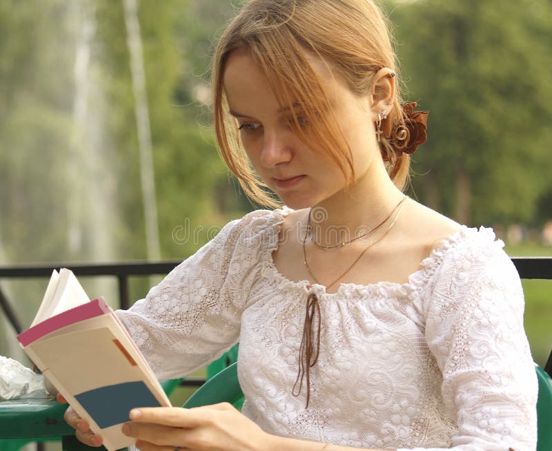 Young girl reading a book in the park. Young girl reading a book in the park