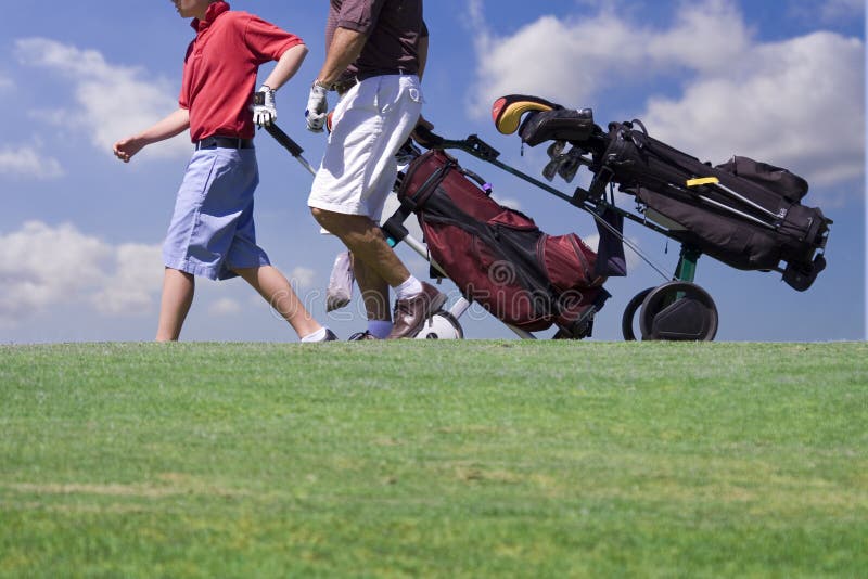 Father and son walking on golfcourse. Father and son walking on golfcourse