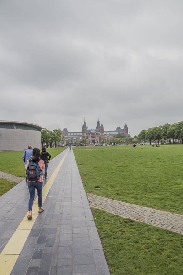 Het lopen van Weg in Museumplein bij het Nederland van Amsterdam stock afbeelding Het lopen van Weg in Museumplein bij het Nederland van Amsterdam stock afbeelding
