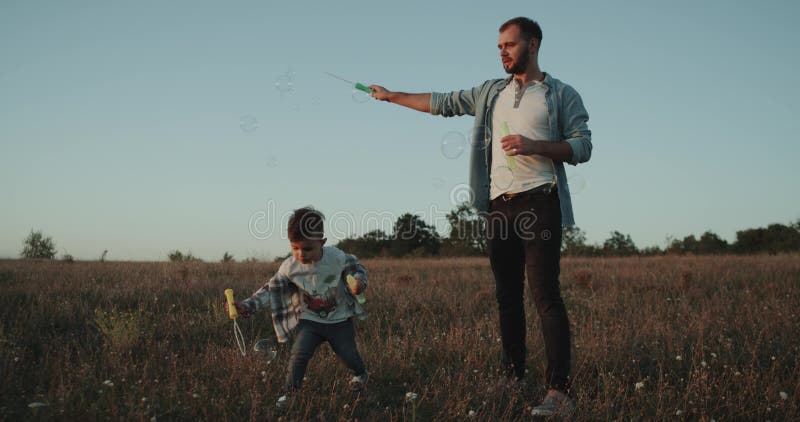 Het maken borrelt bij zonsondergang, papa met zijn zoon, drie jaar oud, perverse mane perverse manogenblik samen bestedend stock video Het maken borrelt bij zonsondergang, papa met zijn zoon, drie jaar oud, perverse mane perverse manogenblik samen bestedend stock video