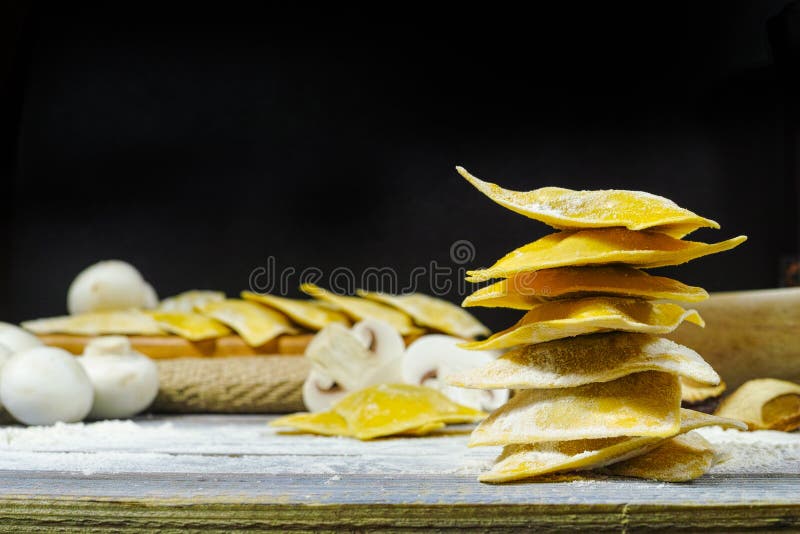 Making home made ravioli with porcini mushrooms on blue wooden table top. Making home made ravioli with porcini mushrooms on blue wooden table top