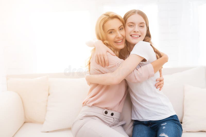 Moeder en tienerdochter omhelzen elkaar stock foto