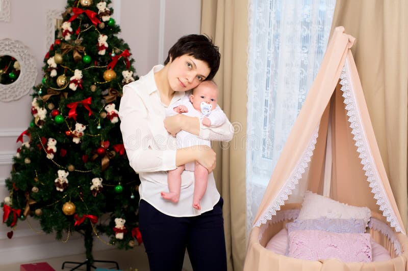 Het mamma koestert haar dochter dichtbij de wieg royalty-vrije stock fotografie Het mamma koestert haar dochter dichtbij de wieg royalty-vrije stock fotografie