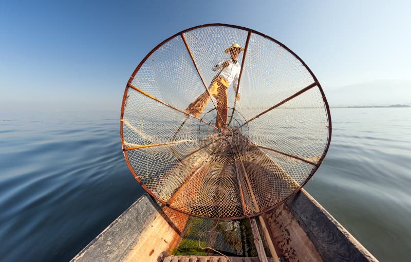 Het meervisser van Birma Myanmar Inle op boot die vissen vangen stock foto Het meervisser van Birma Myanmar Inle op boot die vissen vangen stock foto