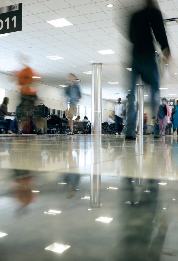 Long exposure motion blur at extremely low angle of people rushing along the airport concourse. Long exposure motion blur at extremely low angle of people rushing along the airport concourse.