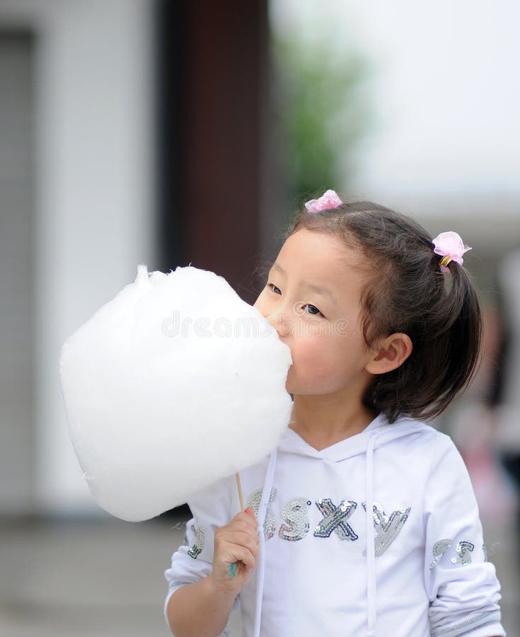 Het meisje dat van Yong gesponnen suiker eet