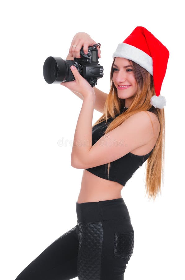 Het meisje in de hoed van Santa Claus met een camera Jonge meisjesfotograaf Christmas Kerstmis selfie stock foto Het meisje in de hoed van Santa Claus met een camera Jonge meisjesfotograaf Christmas Kerstmis selfie stock foto