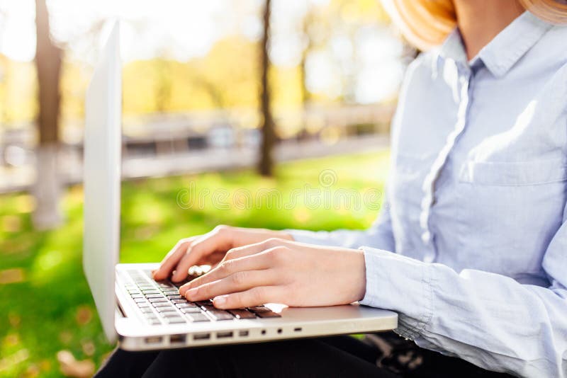 Het meisje die aan laptop, handen werken typt tekst, close-up in het park royalty-vrije stock afbeeldingen Het meisje die aan laptop, handen werken typt tekst, close-up in het park royalty-vrije stock afbeeldingen