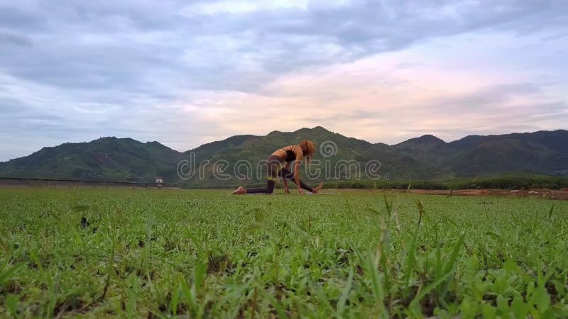 Het Meisje die van Flycambenaderingen Yoga doen tegen Heuvels onder Wolken