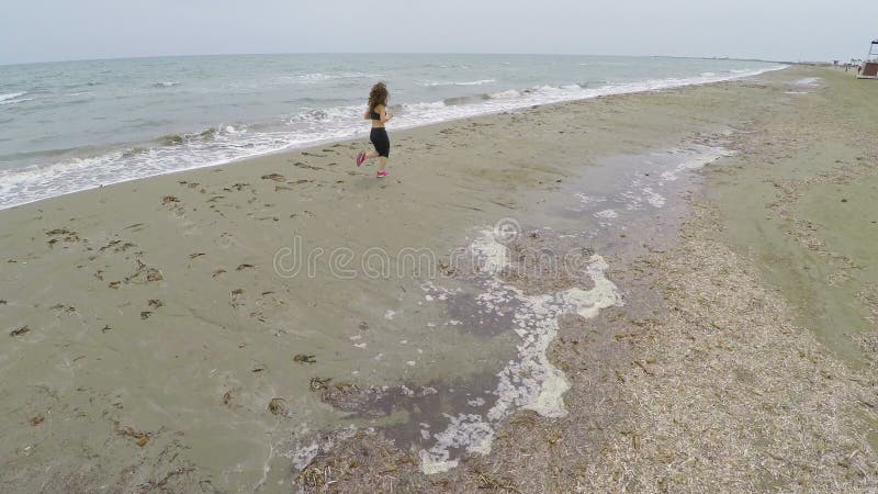 Het meisje die van Nice langs het strand, atleet opleiding op kust, luchtschot lopen