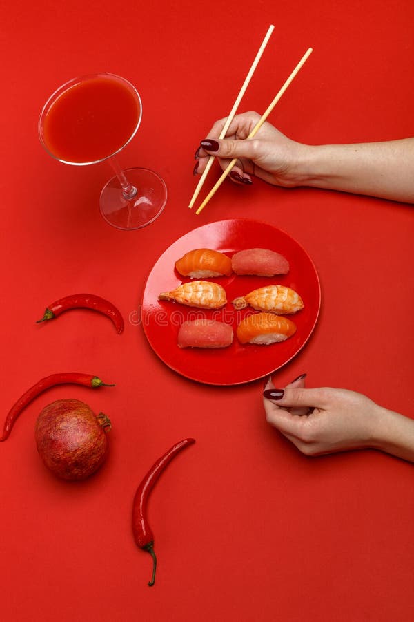 Het meisje eet sushi op een rode plaat Creatief concept restaurantlijst het plaatsen stock foto Het meisje eet sushi op een rode plaat Creatief concept restaurantlijst het plaatsen stock foto