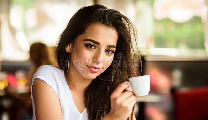 Het meisje geniet van aromatische koffiedrank Drinkt de meisjes aantrekkelijke schitterende donkerbruine verschijning van het Mid royalty-vrije stock foto's Het meisje geniet van aromatische koffiedrank Drinkt de meisjes aantrekkelijke schitterende donkerbruine verschijning van het Mid royalty-vrije stock foto's