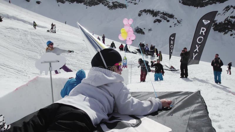 Het meisje in GLB van folie wordt gemaakt ligt met gele luchtballon die Snowboarder het berijden