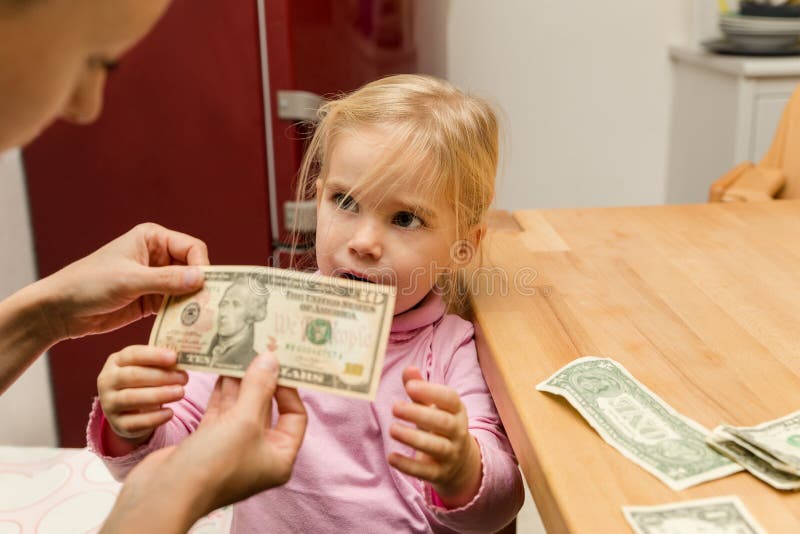 Het meisje krijgt tien dollars van haar moeder royalty-vrije stock fotografie Het meisje krijgt tien dollars van haar moeder royalty-vrije stock fotografie