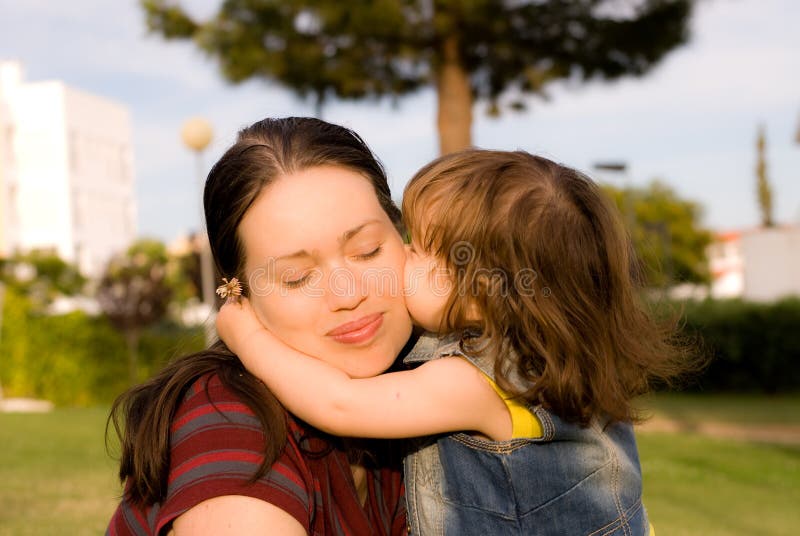 Het meisje kust haar moeder stock fotografie
