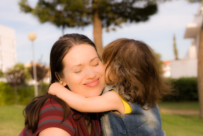 Het meisje kust haar moeder stock foto