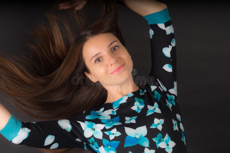 Het meisje met het ontwikkelen van lang haar op zwarte achtergrond stock afbeelding Het meisje met het ontwikkelen van lang haar op zwarte achtergrond stock afbeelding