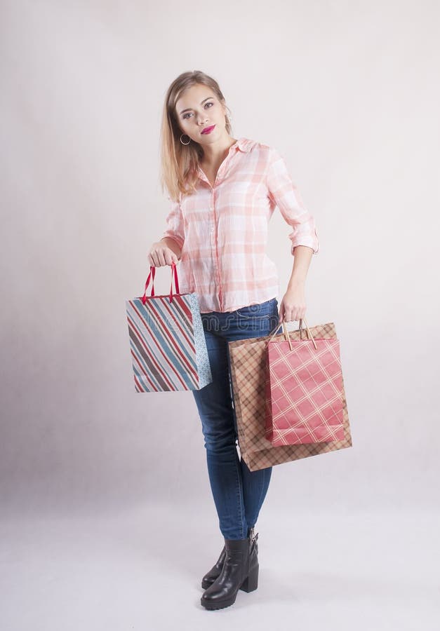 Het meisje met het winkelen zakken in jeansstudio winkelt vrij royalty-vrije stock foto Het meisje met het winkelen zakken in jeansstudio winkelt vrij royalty-vrije stock foto