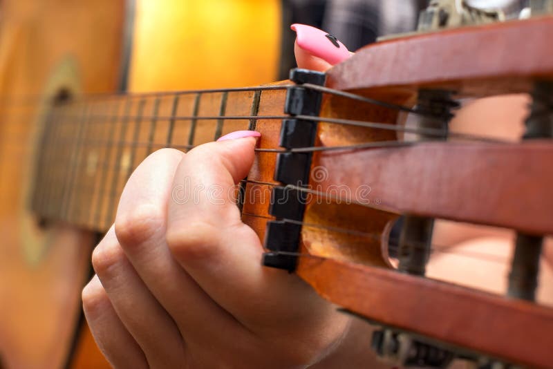 Het meisje plukt snaar het vastklemmen lijstwerken op fretboard Vrouwelijke vrouwenhand het spelen gitaar dicht omhoog royalty-vrije stock foto Het meisje plukt snaar het vastklemmen lijstwerken op fretboard Vrouwelijke vrouwenhand het spelen gitaar dicht omhoog royalty-vrije stock foto