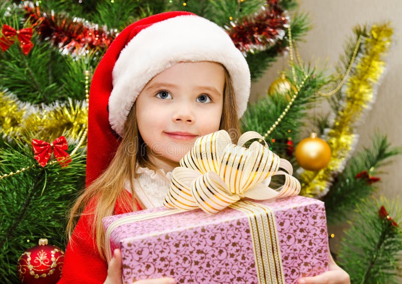 Cute little girl in santa hat with present have a christmas. Cute little girl in santa hat with present have a christmas