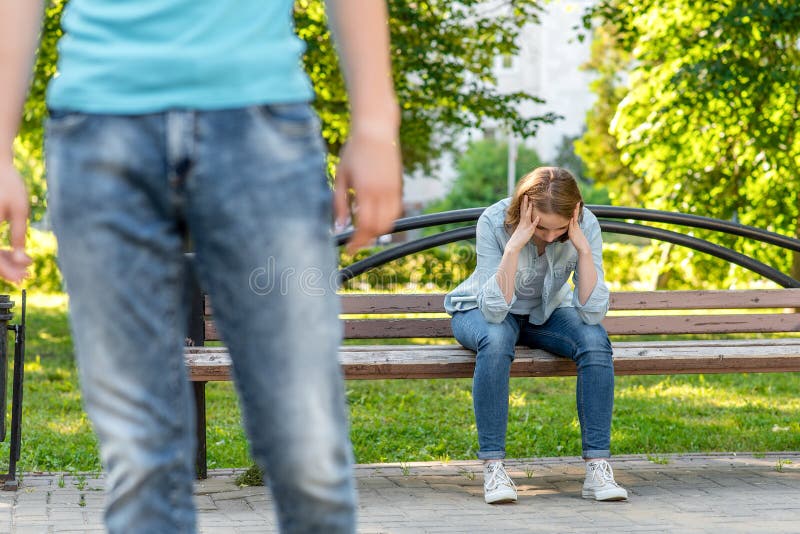 Het meisje schreeuwt op bank In de zomer in het park in aard De jonge man verlaat haar De frustratie is een wantrouwen stock foto's Het meisje schreeuwt op bank In de zomer in het park in aard De jonge man verlaat haar De frustratie is een wantrouwen stock foto's