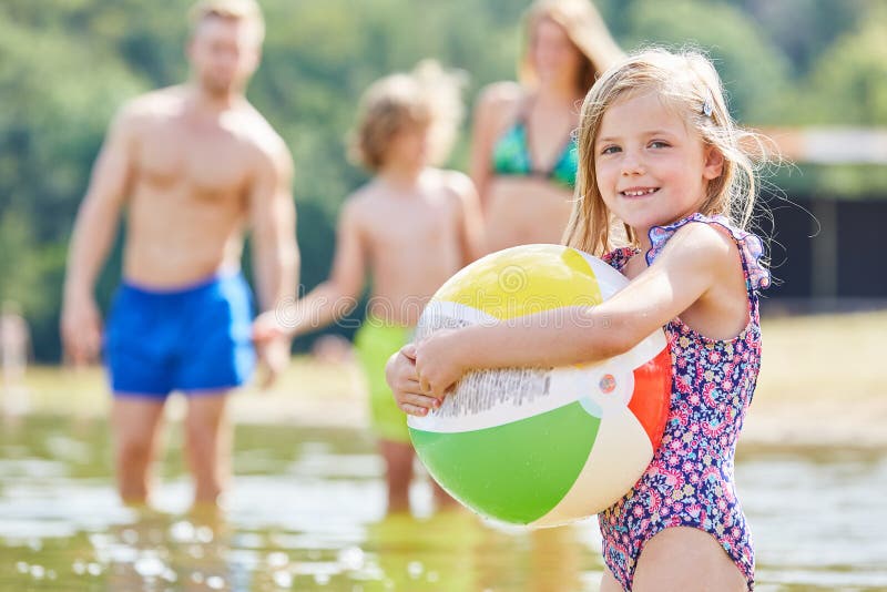 Het meisje speelt met een kleurrijke bal in het overzees stock foto Het meisje speelt met een kleurrijke bal in het overzees stock foto