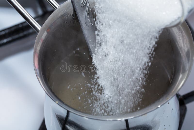 Het mengen van suiker en gesmolten gelatine royalty-vrije stock foto's Het mengen van suiker en gesmolten gelatine royalty-vrije stock foto's