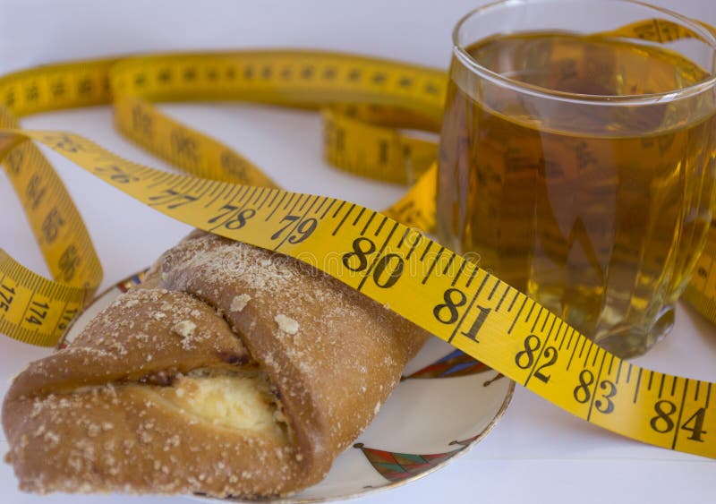 Het meten van band die op pastei, cakes naast een glas thee liggen royalty-vrije stock afbeeldingen Het meten van band die op pastei, cakes naast een glas thee liggen royalty-vrije stock afbeeldingen