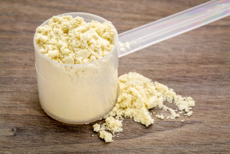 Het meten van lepel van weiproteïnepoeder stock foto's
