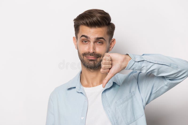 Het Millennial kerel tonen beduimelt onderaan studio hoofdschot royalty-vrije stock afbeelding Het Millennial kerel tonen beduimelt onderaan studio hoofdschot royalty-vrije stock afbeelding