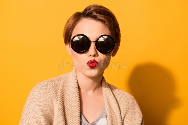 Het modieuze jonge leuke meisje in in zonnebril verzendt een kus a stock afbeelding Het modieuze jonge leuke meisje in in zonnebril verzendt een kus a stock afbeelding