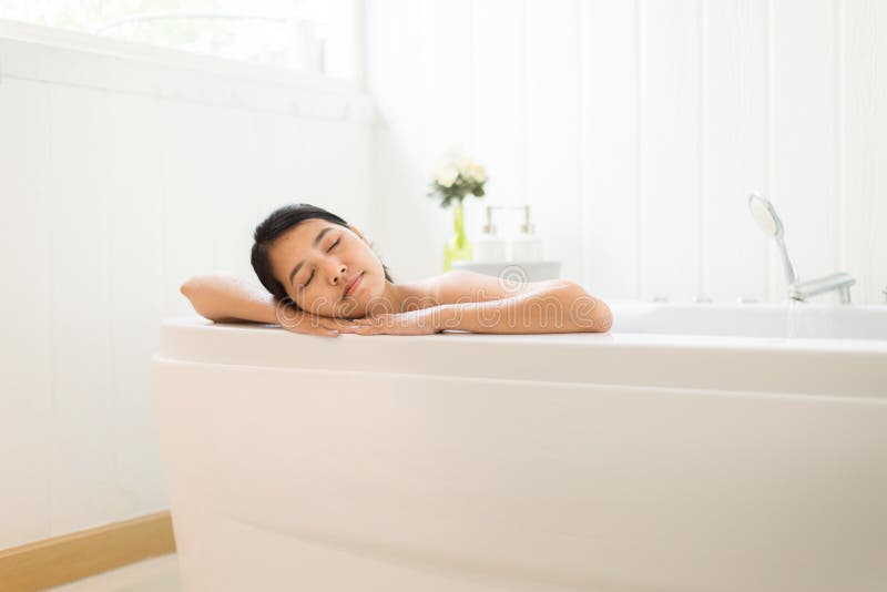 Het mooie Aziatische vrouwen dichte oog en ontspant op Jacuzzibadkuip in de ochtend, Vrouwelijk het liggen lichaam in water bij h royalty-vrije stock foto Het mooie Aziatische vrouwen dichte oog en ontspant op Jacuzzibadkuip in de ochtend, Vrouwelijk het liggen lichaam in water bij h royalty-vrije stock foto