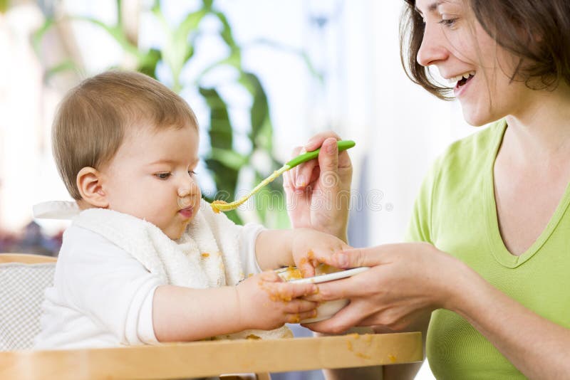Het mooie babyjongen spelen met voedsel terwijl het eten. stock foto's Het mooie babyjongen spelen met voedsel terwijl het eten. stock foto's