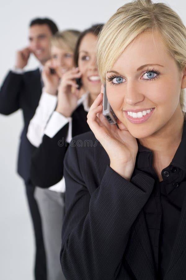 Het mooie Blonde Team van de Vrouw op de Telefoons van de Cel stock fotografie Het mooie Blonde Team van de Vrouw op de Telefoons van de Cel stock fotografie