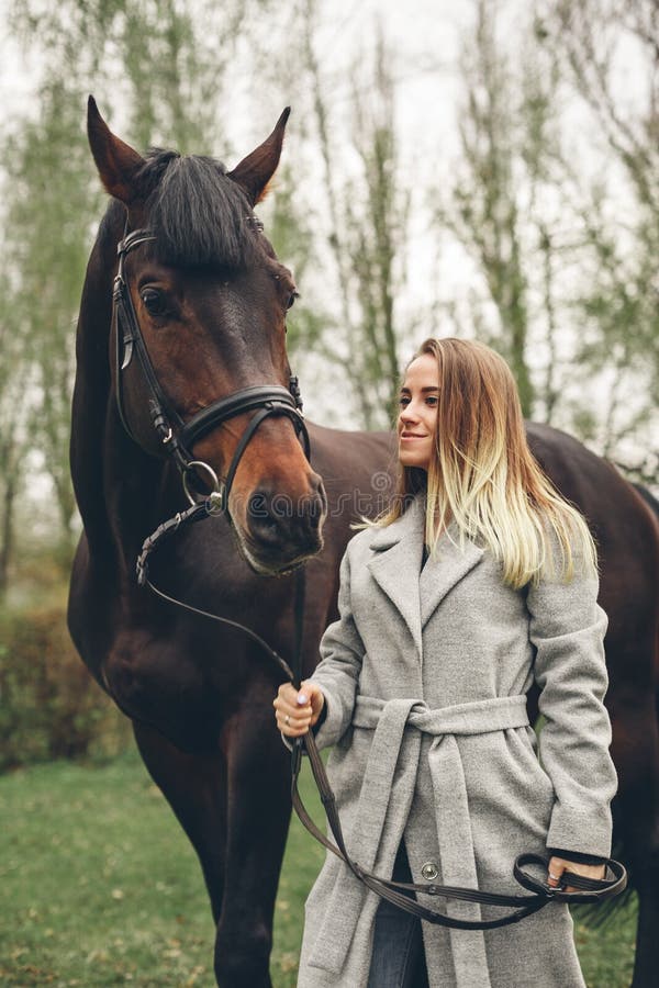 Het mooie meisje communiceert met een paard in het park royalty-vrije stock afbeeldingen Het mooie meisje communiceert met een paard in het park royalty-vrije stock afbeeldingen