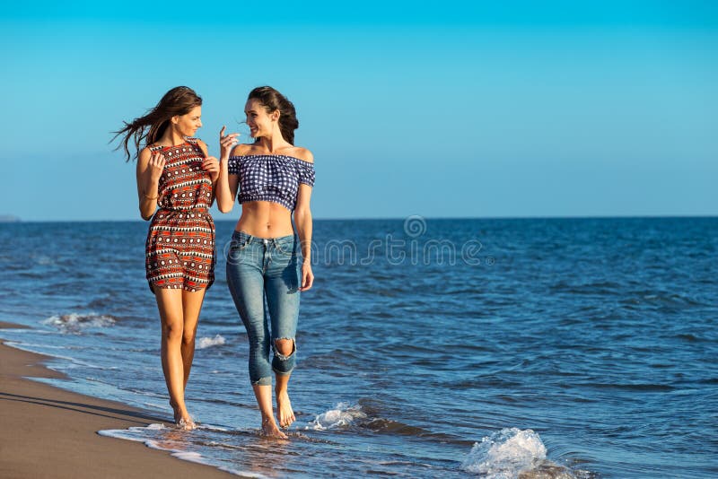 Het mooie meisje heeft een pret met haar meisje op het strand royalty-vrije stock afbeelding Het mooie meisje heeft een pret met haar meisje op het strand royalty-vrije stock afbeelding