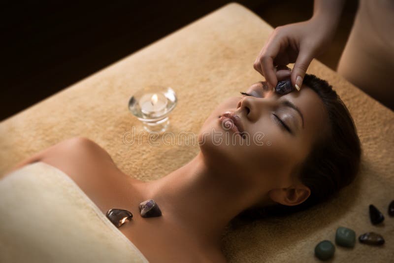 Het mooie meisje heeft massage met chakra-stenen royalty-vrije stock foto Het mooie meisje heeft massage met chakra-stenen royalty-vrije stock foto